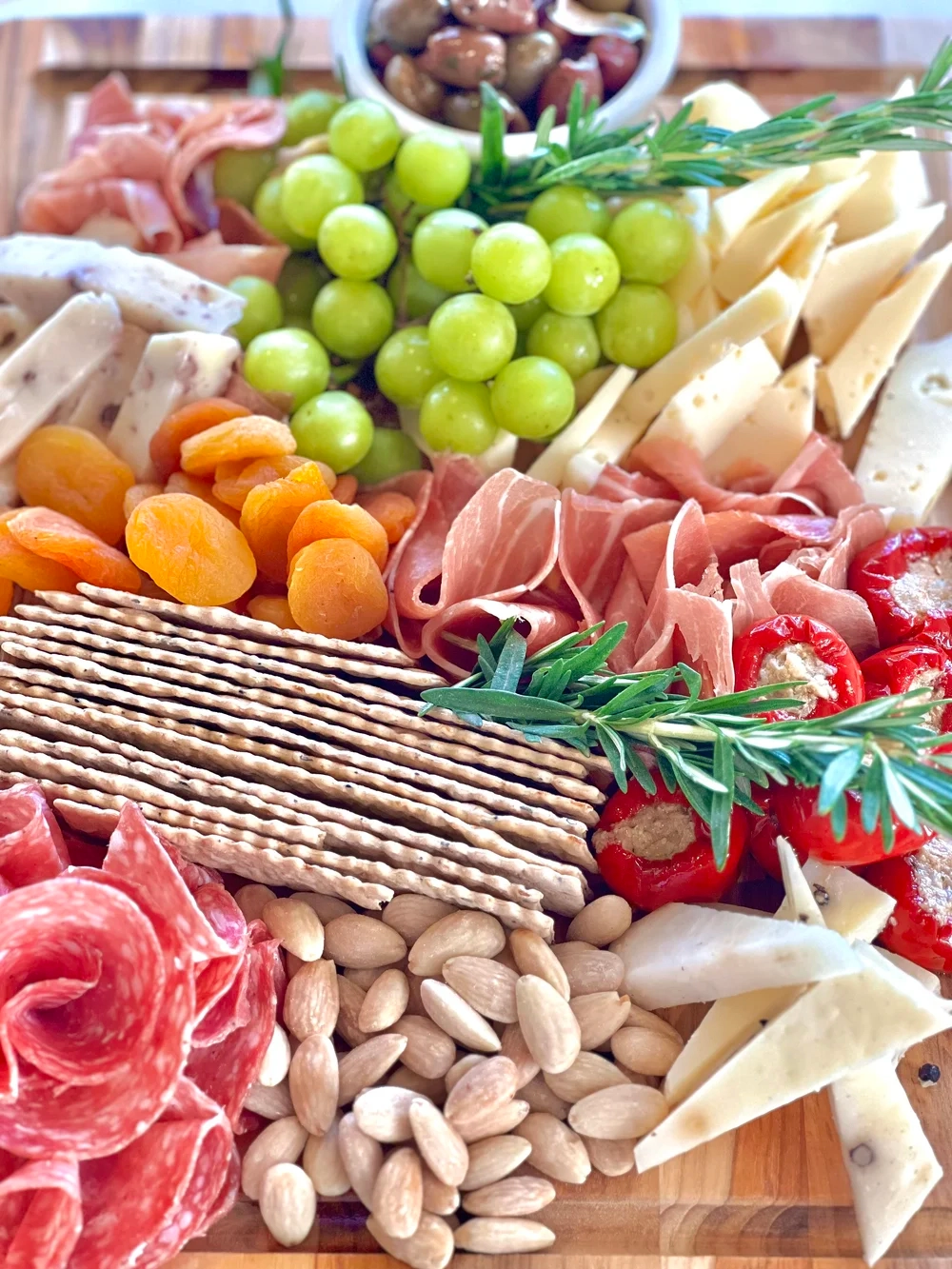 Fresh custom-arranged party charcuterie board on wooden platter